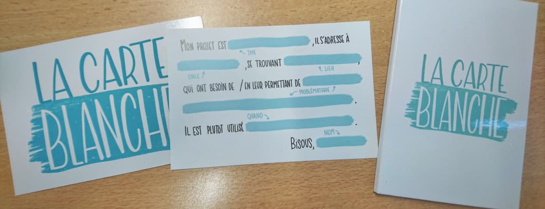 Two printed cards titled La Carte Blanche and a card box. The first one reads "La carte blanche" and is the back of the card. The second one is the front, and is fill-in-the-blank template in French with fields that read: my project is (type), it targets (audience), who are in (place). They needs / my projects lets them (problem). It is rather used (when). Xoxo (name).